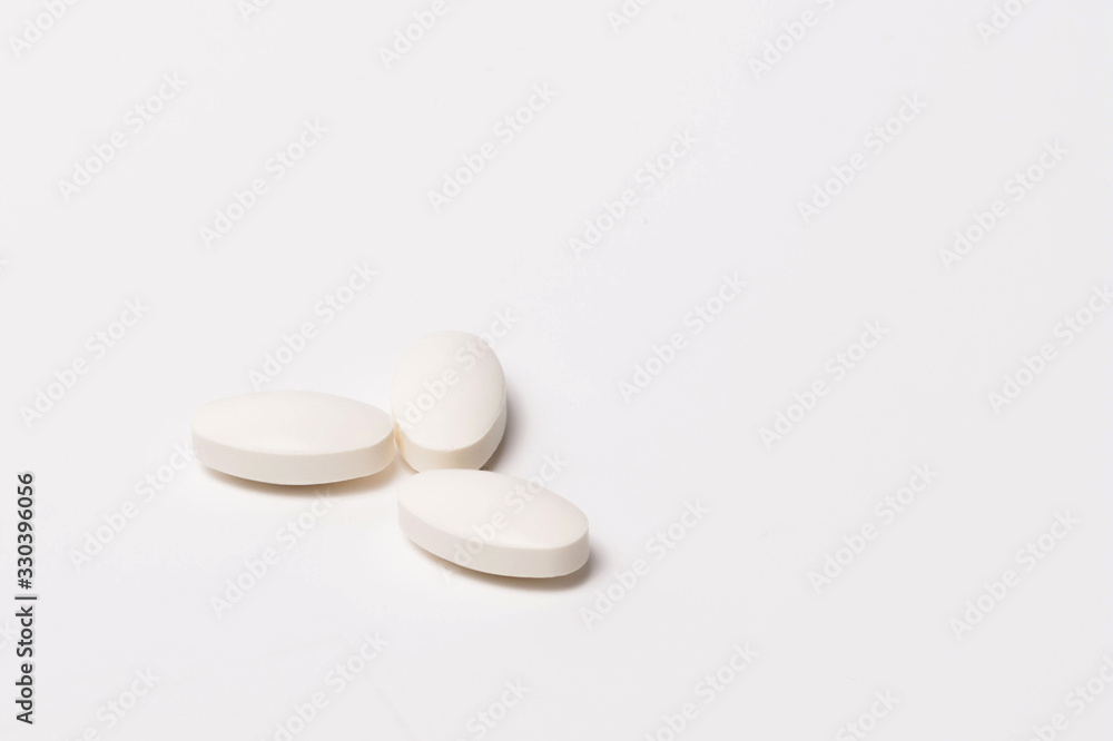 Three white tablet oval shaped on a white background. Isolated Three white tablet oval shaped on a white background. Isolated
