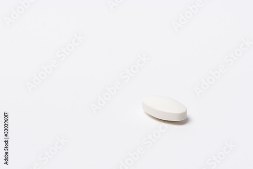 One white tablet oval shaped on a white background
