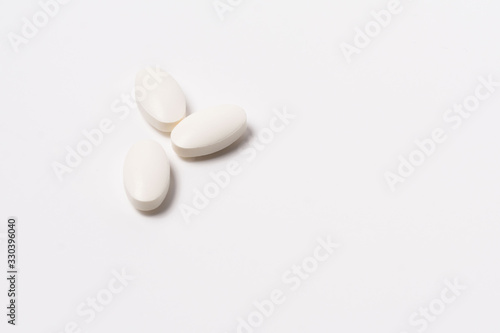 Three white tablet oval shaped on a white background