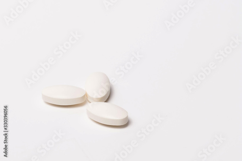 Three white tablet oval shaped on a white background. Isolated