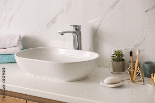 Stylish vessel sink on light countertop in modern bathroom