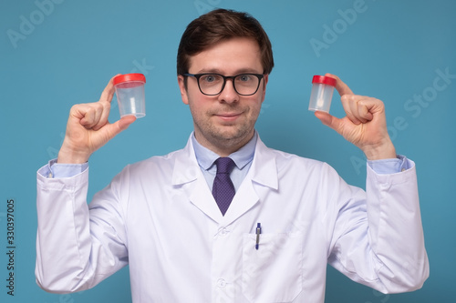 Mature caucaisan doctor or lab scientist holding urine sample cup. photo