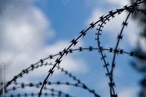 Barbed wire barrier war territory, roadblock quarantine on background.