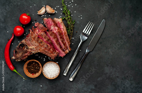 Grilled beef steak with spices on a stone background with copy space for your text.