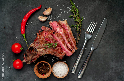 Grilled beef steak with spices on a stone background with copy space for your text.