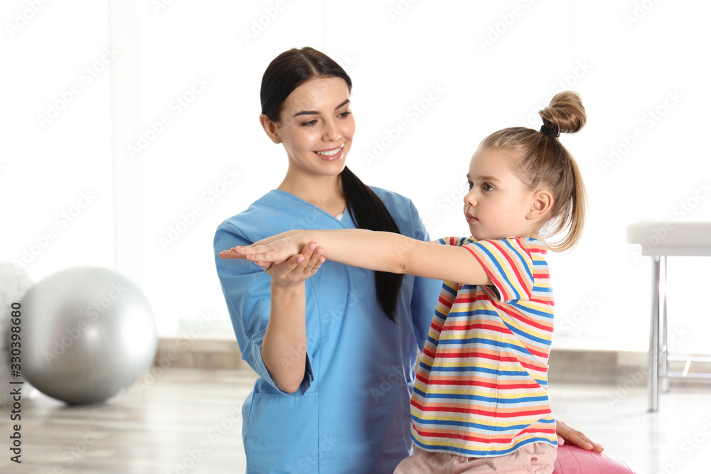 Orthopedist working with little girl in hospital gym Orthopedist working with little girl in hospital gym