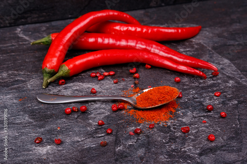Red pods of chili pepper, spoon with paprika.