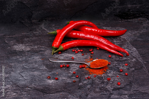 Red pods of chili pepper, spoon with paprika.