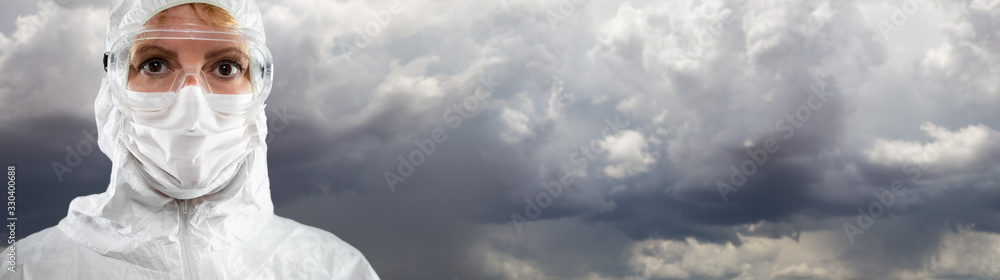 Female Medical Worker Wearing Protective Face Mask and Gear Against Cloudy Stormy Sky. - obrazy, fototapety, plakaty 