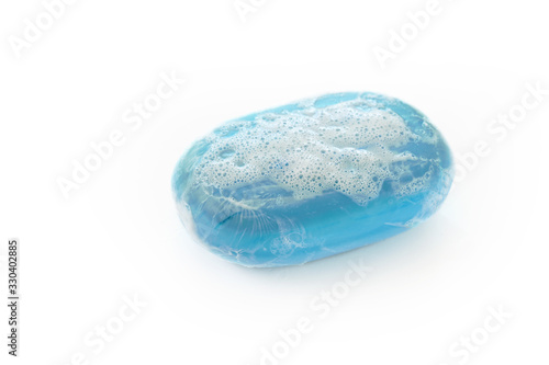 bar of blue soap with lather and bubbles isolated on a white background, health care and hygiene concept against corona virus infection, copy space