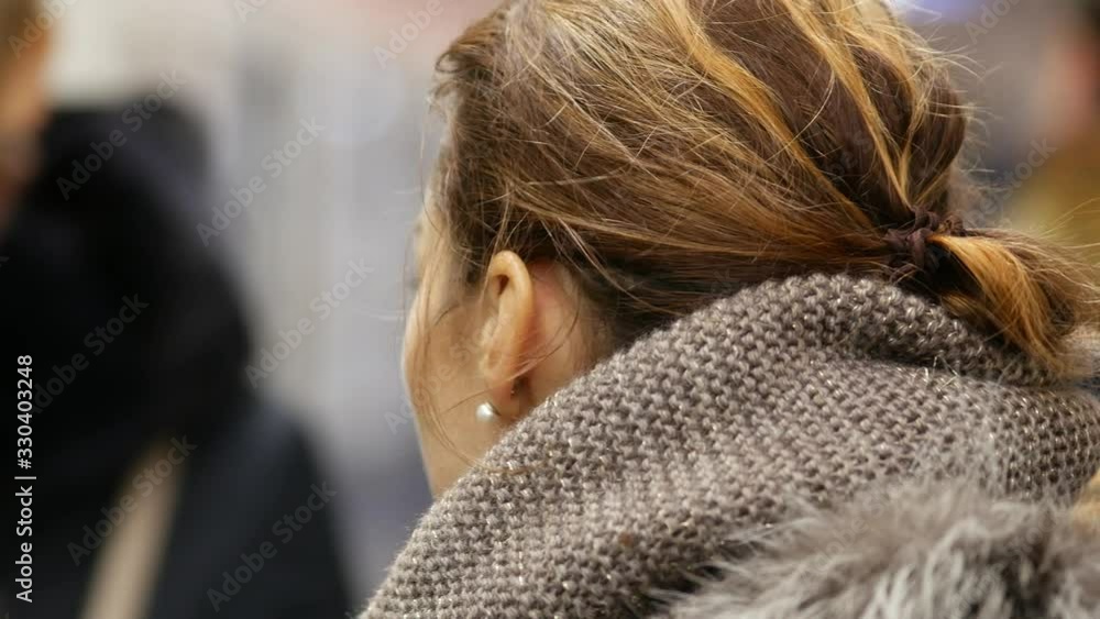 Young pretty girl looking away stands on subway platform during arrival of train. Successful woman in jacket with fur collar on platform of subway in Moscow, Russia. Wind blows hair. Moving cars. Young pretty girl looking away stands on subway platform during arrival of train. Successful woman in jacket with fur collar on platform of subway in Moscow, Russia. Wind blows hair. Moving cars.