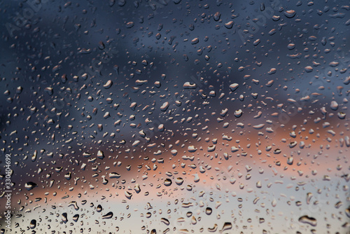Okienna szyba pokryta kroplami deszczu. © boguslavus