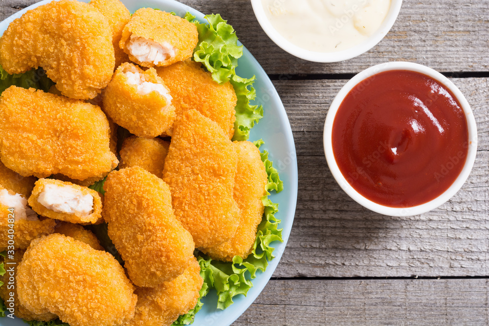 Chicken nuggets in plate on rustic background Chicken nuggets in plate on rustic background