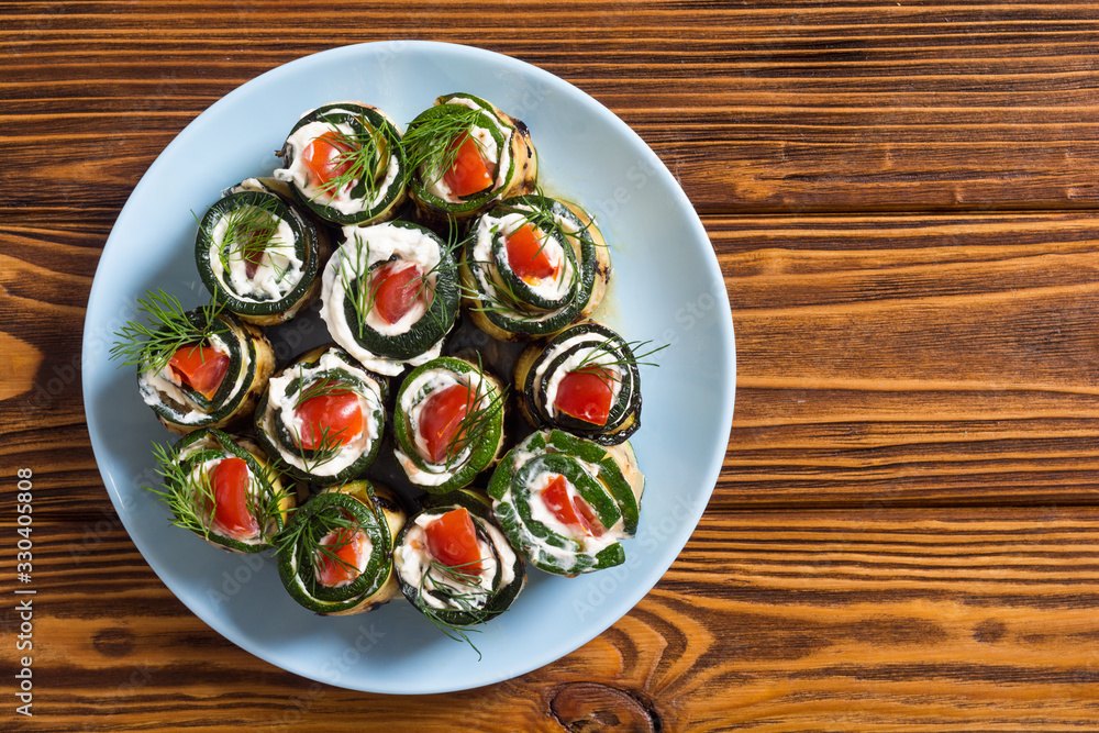 Zucchini rolls with cream cheese , tomatoes and dill