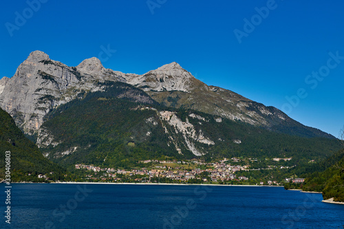 Aerial view over the beautiful Molveno town and Molveno lake, an alpine lake in Trentino, Italy