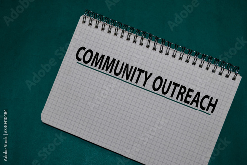 Community Outreach write on a book isolated on Office Desk.