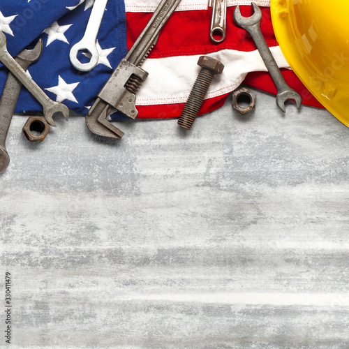 Labor day or American labor concept with construction and manufacturing tools on patriotic US, USA, American flag on white wooden background