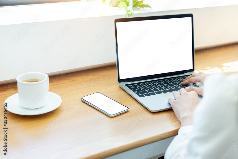 mockup image blank screen computer,cell phone with white background for advertising text,hand woman using laptop texting mobile contact business search information on desk in cafe.marketing,design mockup image blank screen computer,cell phone with white background for advertising text,hand woman using laptop texting mobile contact business search information on desk in cafe.marketing,design
