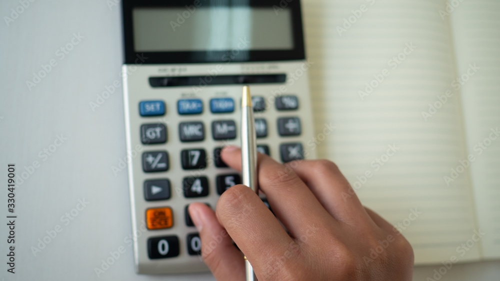 hand of using calculator to calcutate finance for business growth. hand of using calculator to calcutate finance for business growth.