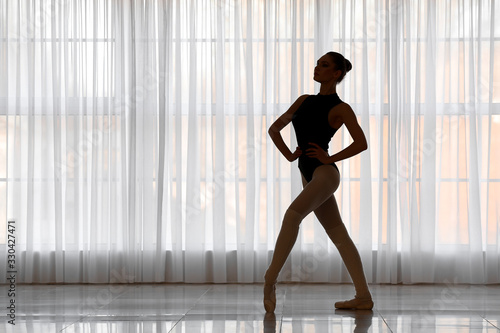 Silhouette of beautiful young ballerina in dance studio