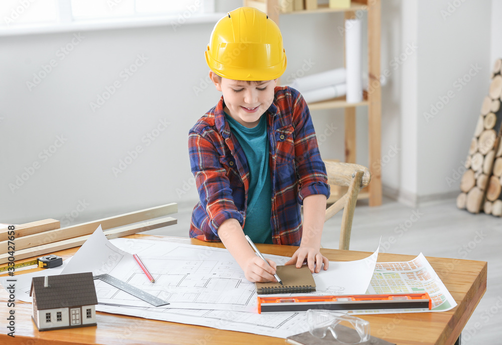 Cute little builder with drawings in room Cute little builder with drawings in room