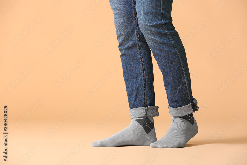 Male legs in socks and jeans on color background Male legs in socks and jeans on color background