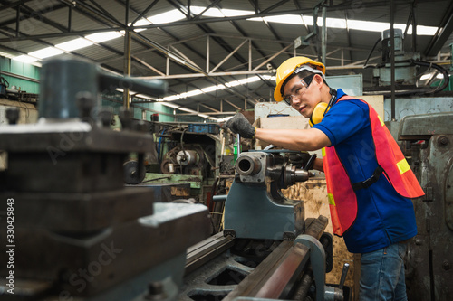 Asian Industrial workers are working on projects in large industrial plants with many devices.