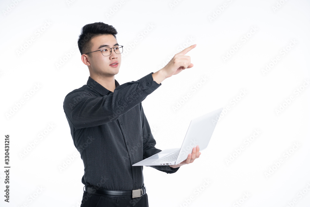 A young Asian man is using his mobile phone and laptop A young Asian man is using his mobile phone and laptop