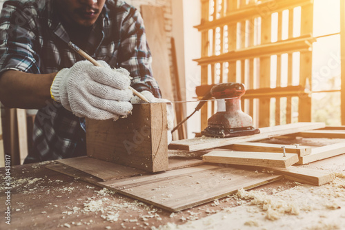 Obraz na plátne Carpenter working on wood craft at workshop to produce construction material or wooden furniture