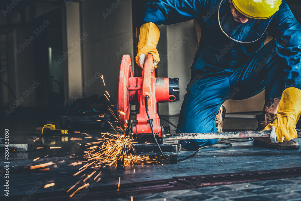 Professional mechanic is cutting steel metal with rotating diamond ...