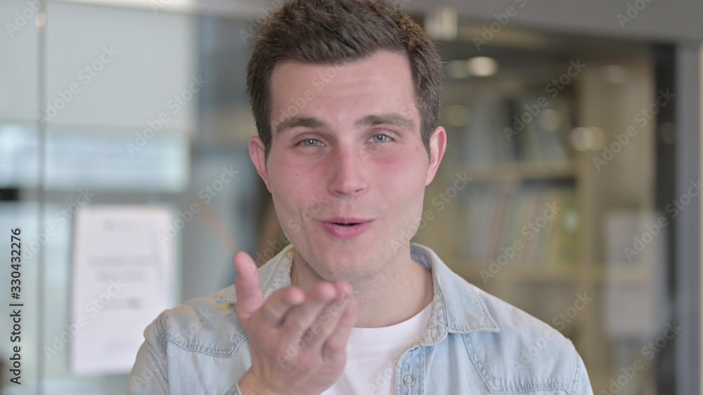 Naklejka premium The Portrait of Attractive Young Male Designer giving Flying Kiss