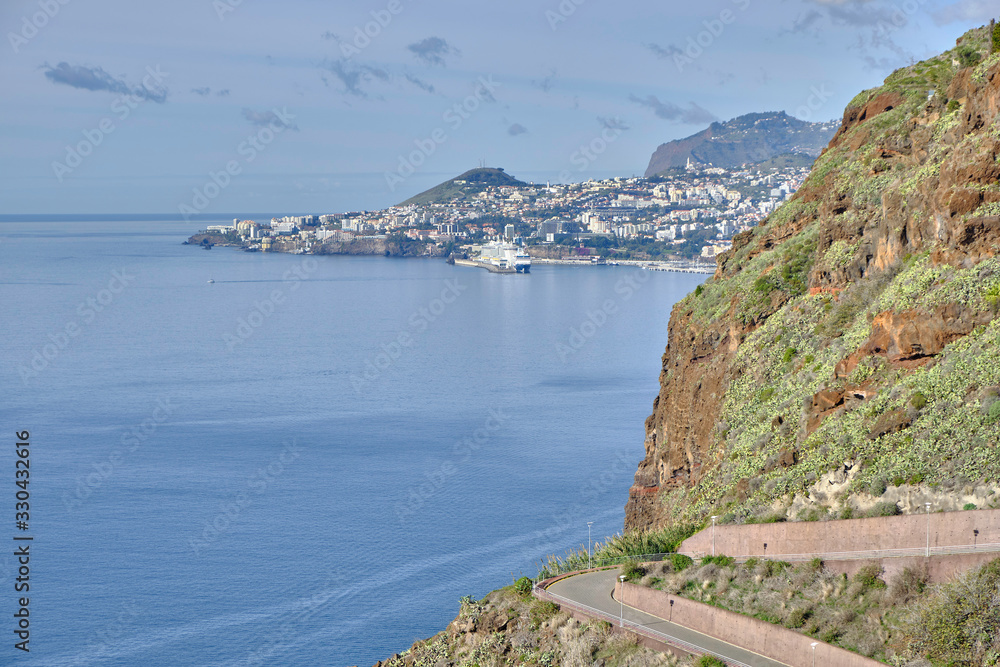 Scenic view of Funchal - capital of Portugal's Autonomous Region of Madeira. Beautiful summer sunny look of small town on hills on paradise tropical island in Atlantic ocean.