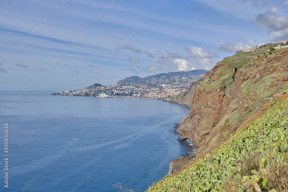 Fototapeta premium Scenic view of Funchal - capital of Portugal's Autonomous Region of Madeira. Beautiful summer sunny look of small town on hills on paradise tropical island in Atlantic ocean.