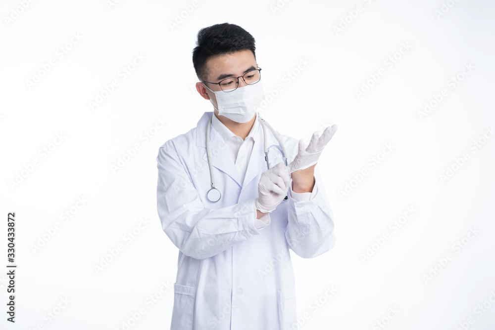 An Asian male doctor works on a laptop
