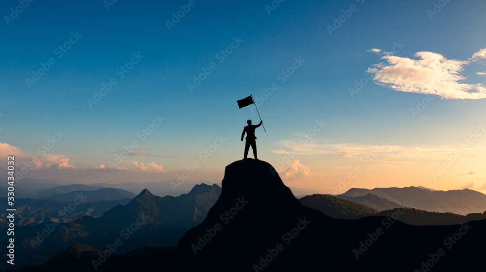 silhouette of businessman with flag on mountain top over sunset sky background, business, success, leadership and achievement concept.