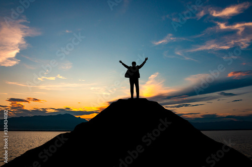 silhouette of businessman on mountain top over sunset sky background, business, success, leadership and achievement concept
