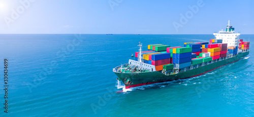 Aerial infront of cargo ship carrying container and running for export goods from cargo yard port to custom ocean concept freight shipping by ship .webinar banner forwarder mast
