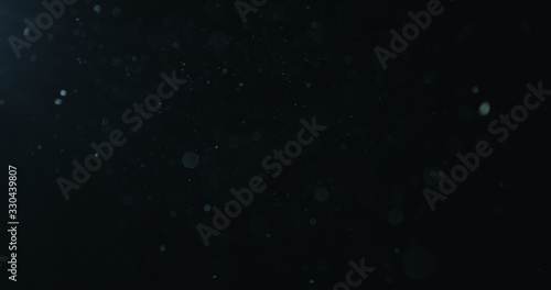 natural dust particles float in air on black background