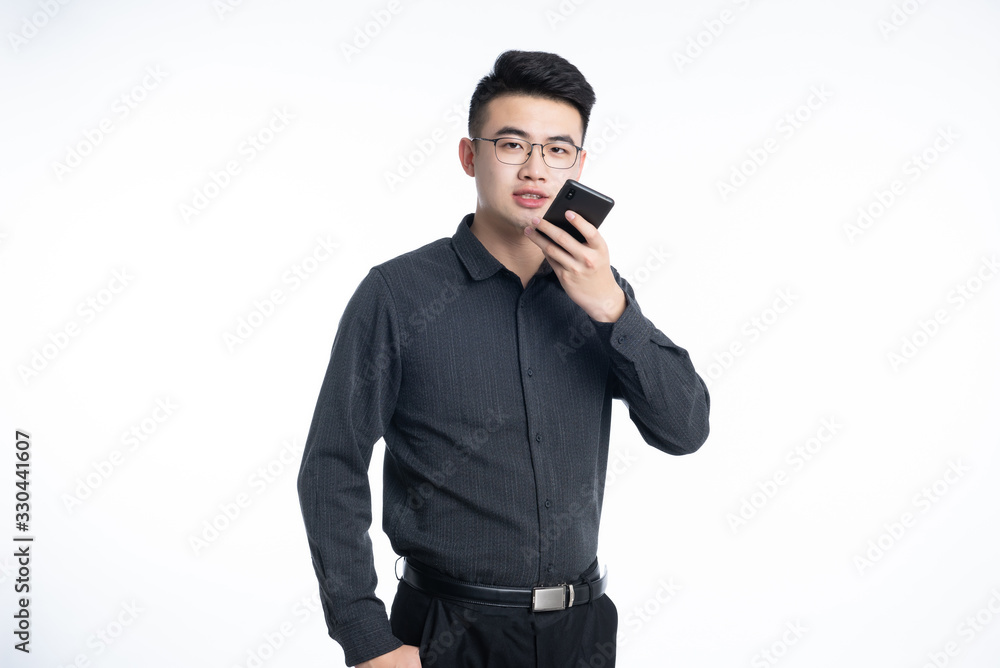 A young Asian business man stood behind his desk A young Asian business man stood behind his desk