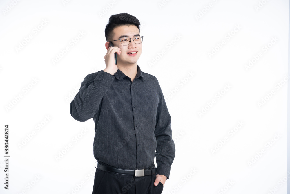 A young Asian business man stood behind his desk A young Asian business man stood behind his desk