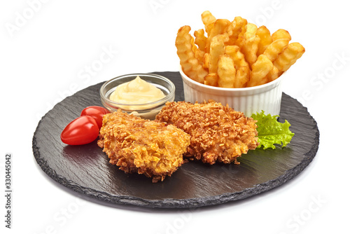 Breaded chicken fillet with french fries on a stone plate, isolated on white background
