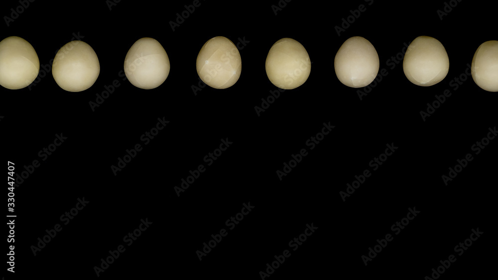 Pale creamy white chocolate Easter eggs on a plain black background Pale creamy white chocolate Easter eggs on a plain black background