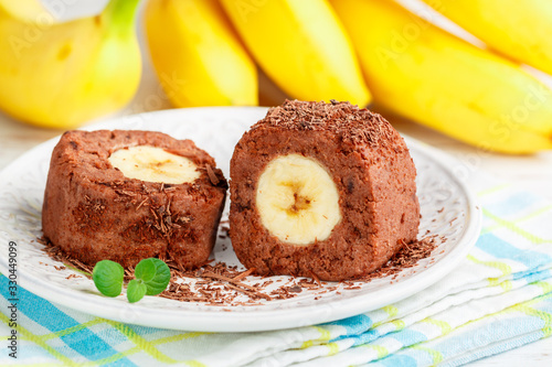 Delicious healthy homemade dessert of bananas, chocolate and cream cheese or ricotta. Banana rolls on a white plate. Treats for kids. Selective focus
