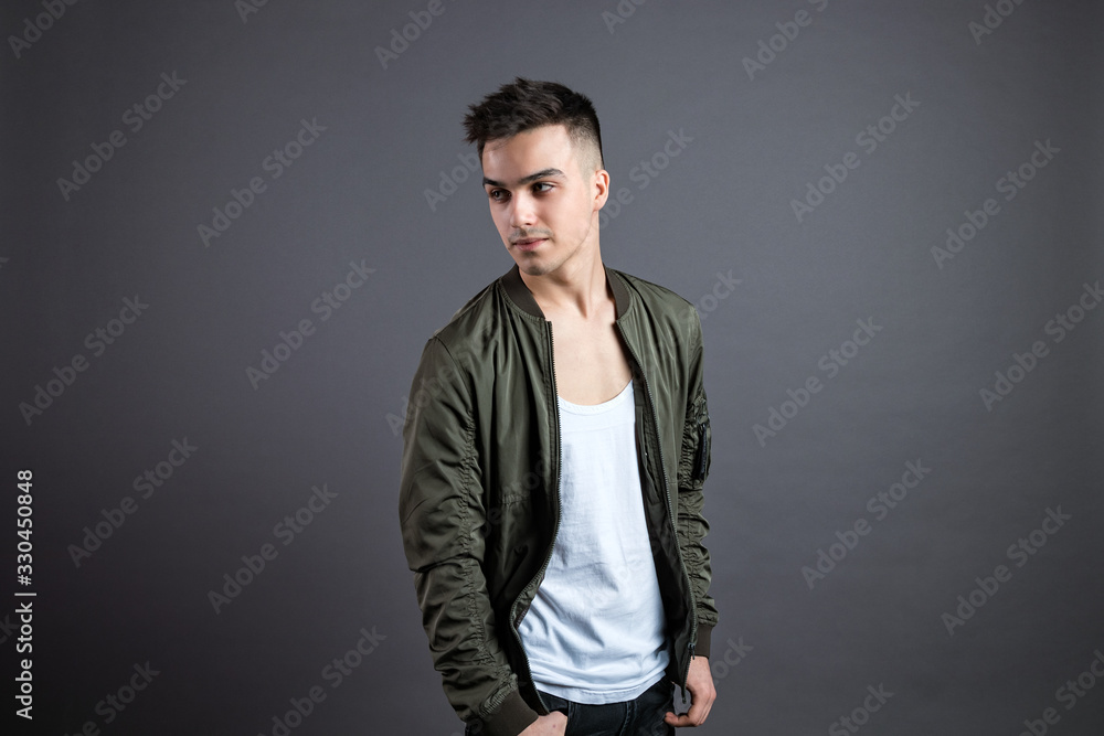 Young serious man posing in studio. Gray background Young serious man posing in studio. Gray background