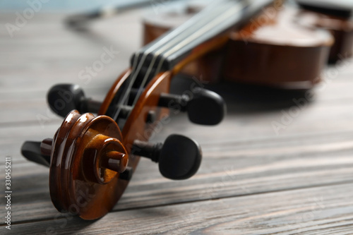 Classic violin on wooden background, closeup view