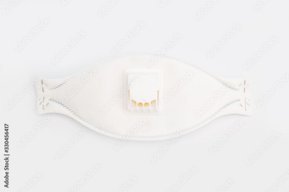 Fototapeta premium Protective face mask with filter for face from contamination, viruses, flu and coronavirus on white background . top view.Health care and surgical concept.