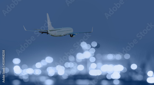 Airplane flies over the city of night with bokeh