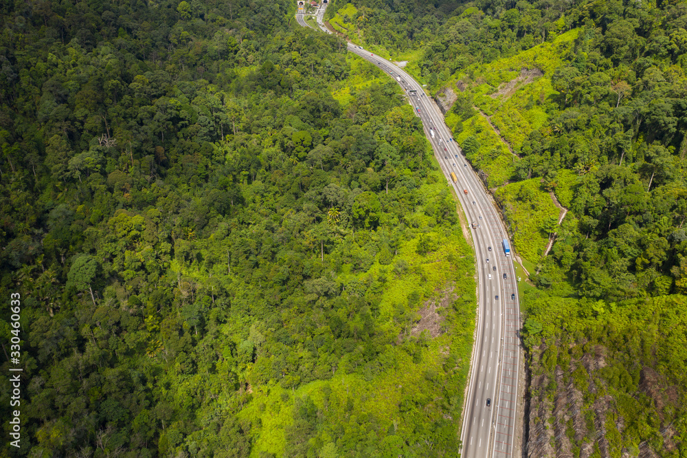 Aerial view of Malaysia's North South highway cutting through mountain jungle. Aerial view of Malaysia's North South highway cutting through mountain jungle.