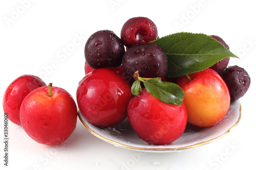 Plums and cherries on dish