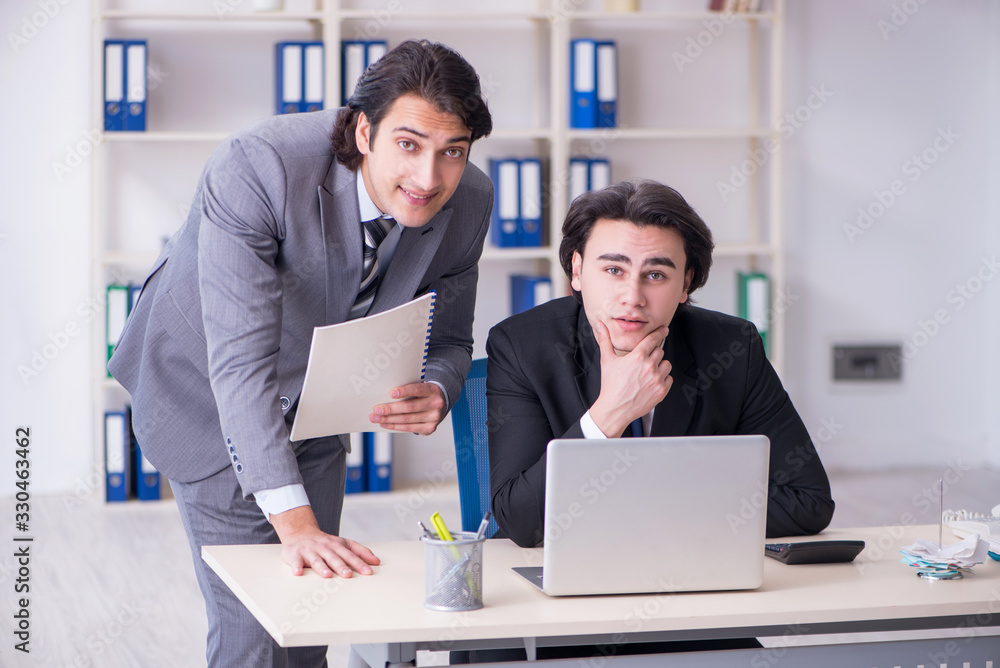 Two young employees working in the office